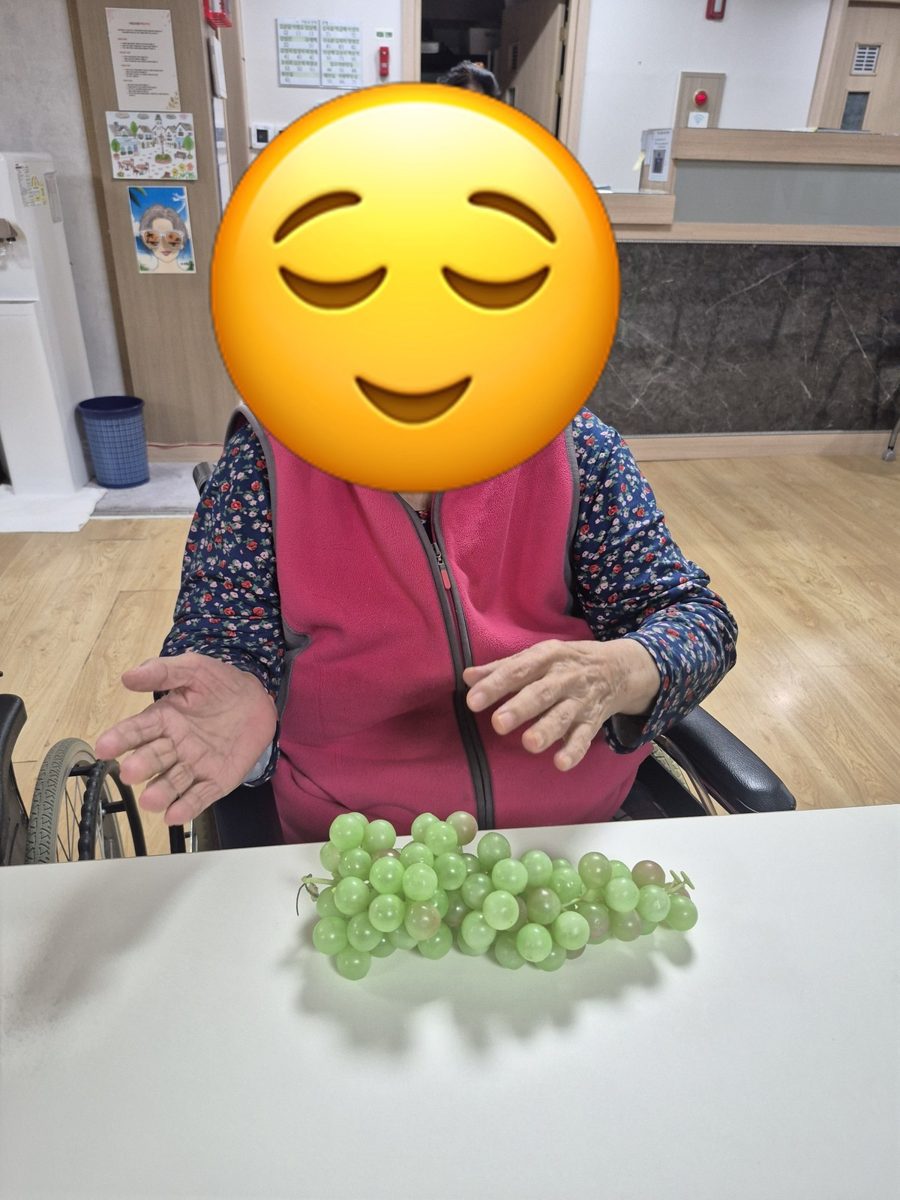 프로그램실에서 완성한 포도 작품을 앞에 두고 앉아 계신 어르신