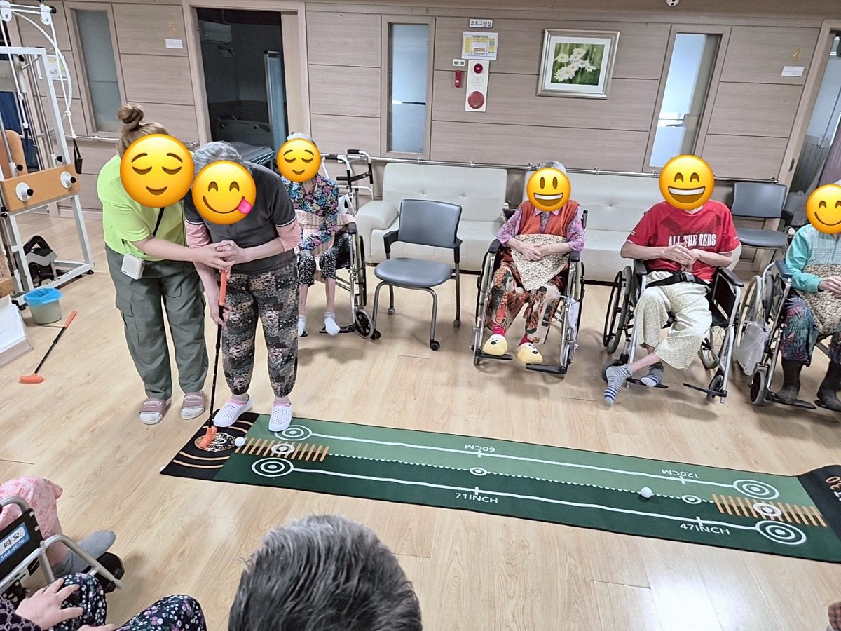 퍼팅 매트 앞에서 함께 체조하는 어르신들과 선생님